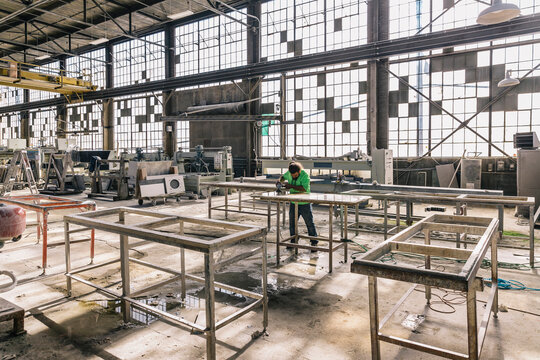 Hispanic Man at work at Industrial Company with grinding