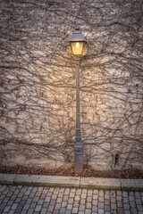 Fototapeta na wymiar Paris, France - 02 26 2021: Montmartre district. A Street lamp along a wall