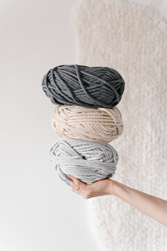 Crop person with balls of yarn