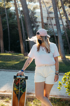 Curvy blonde skate girl with cap and mask to prevent coronavirus