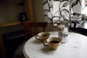 black coffee in two cups on a white marble table. morning coffee ritual