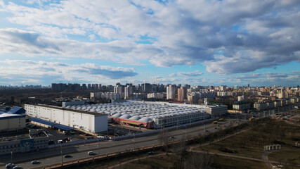Megapolis in the spring. The factory is visible. Around it are high-rise city houses.