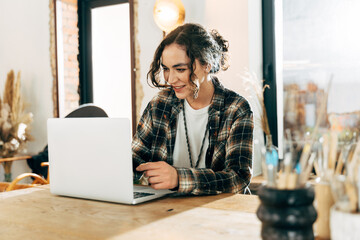Female sitting at the table with her laptop computer while working remotely