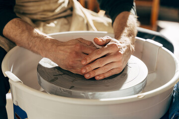 Fototapeta premium Sculptor in the workshop makes a jug out of earthenware