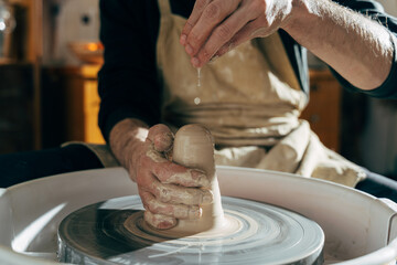 Sculptor in the workshop makes a jug out of earthenware