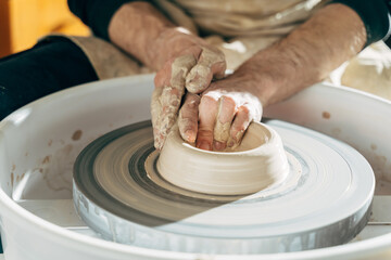 Professional man using mechanic pottery made earthenware for show in sculpture culture