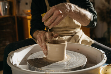 Craftsman artist shapes pot at the studio