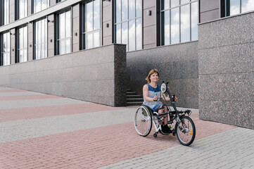 Content woman riding rehabilitation special needs tricycle in city