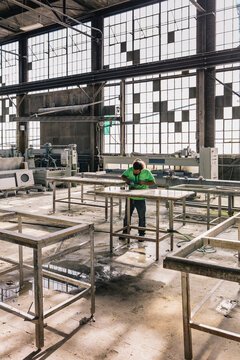 Hispanic Man polishing countertop at Industrial Company