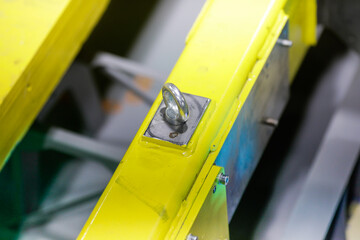 Shallow depth of field (selective focus) image with details of industrial metallic nuts and bolts in a heavy factory.