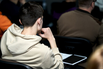 Rear view of a young man attending a business training seminar.......