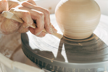 Potter modeling ceramic pot from clay on a potter's wheel