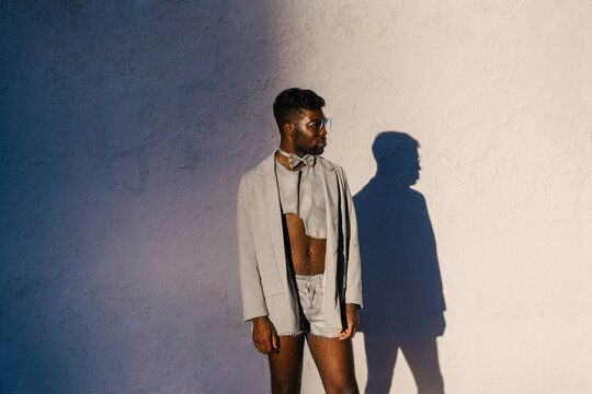Stylish gay african american man posing over concrete wall