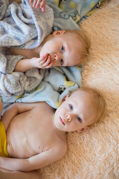 two children are lying on the bed