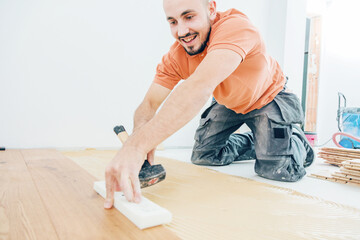 craftsmanr  laying parquet flooring in a modern house