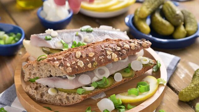  Dutch herring in a sandwich. Toast with Dutch herring, onions, pickles. Traditional rustic appetizer with seafood. Popular food in the netherlands. 