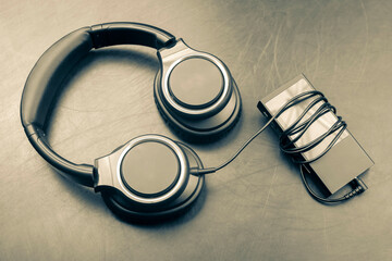 Headphones for listening to music with digital audio player on dark background