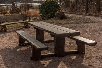 Wooden table and benches in a park.