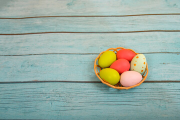 Easter eggs lie on a blue wooden texture. Place for advertisements and text.