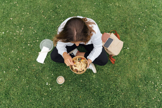 Woman Eating in the Park - Powered by Adobe