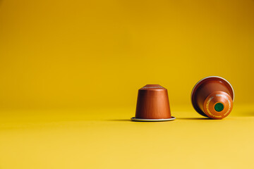 Set of coffee capsules lying on yellow background