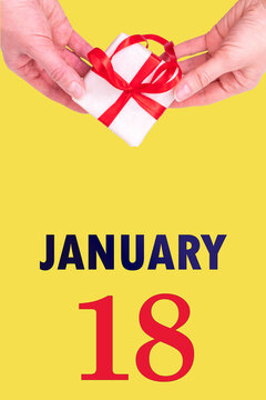 January 18th. Festive Vertical Calendar With Hands Holding White Gift Box With Red Ribbon And Calendar Date 18 January On Illuminating Yellow Background. Winter month, day of the year concept.