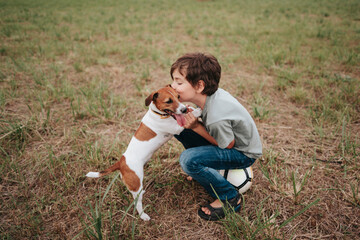 A young boy with his dog in a rural area.