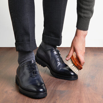Man in stylish handmade leather shoes on a light background