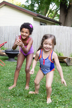 Friends of different races playing happily together in their backyard