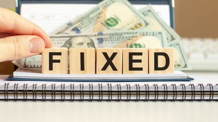 Wooden blocks with the word Fixed. Capital gains. Market trading and pricing.
