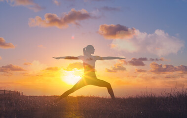 Body health and balance. Young female doing stretching exercises outdoors at sunrise. 