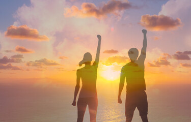 Fototapeta premium People power, and teamwork. Man and woman with fist up in the air facing the sunrise. 