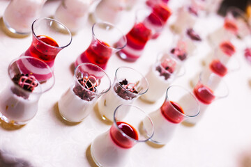 close-up of delicious desserts in small glasses at wedding recep