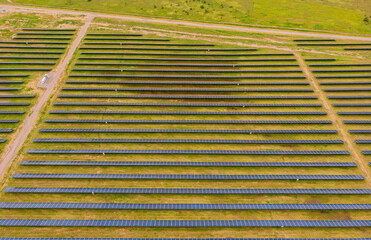 Solar panel produces green, environmentaly friendly energy from the setting sun. Aerial view from drone.