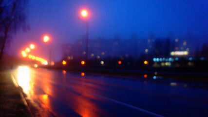 Fototapeta na wymiar Night city and road in fog, blurred background.