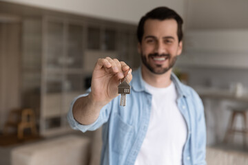 Close up of happy young Caucasian male renter or client show keys buy house or apartment. Smiling man feel excited celebrate relocation moving to own home. Real estate, rental, rent concept.