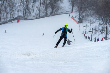 View down slope, skiing, skiers lift, blurred selective focus. Winter sports and recreation