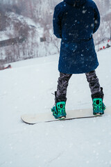 Back view of snowboarder standing on ski slope and enjoying mountain landscape. Winter spor, outdoor activities