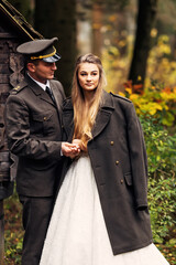 the groom in uniform looks at the bride and she in a wedding dre