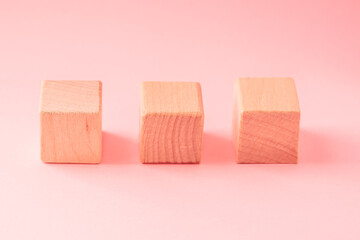 Abstract geometric real wooden cube with surreal layout on pink background