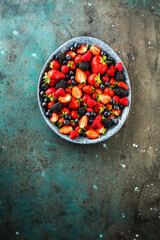 Berries colorful assorted mix of strawberry, blueberry, raspberry, blackberry on dark background