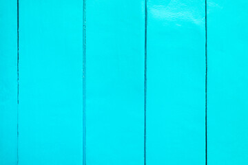 The wall is painted light aqua color. Vertical wooden planks close-up. Paint on wide boards. Place for text, copy space, background, pattern.