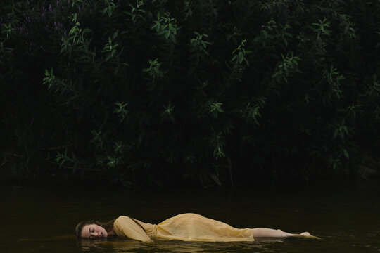 lovely woman lies on her side in the water near the shore