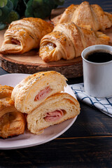 Croissant cut in half and stuffed with ham and cheese