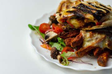 Grilled tortilla wrap with southern style chicken breast with sweet potato fries served on the mix salad