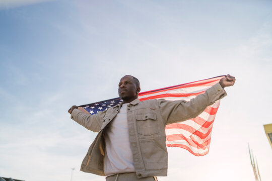 Chico negro con bandera de estados unidos en un parking