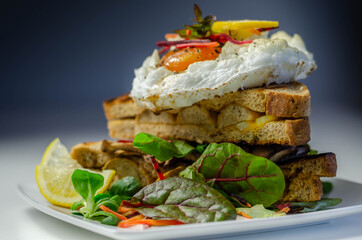 Egg in a cloud on grilled sandwiches with cumberland sausage, tomato and mayonnaise, all served with a fresh salad
