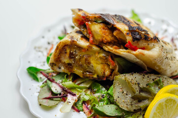 Grilled tortilla wrap with southern style chicken breast served on the mix salad