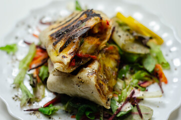 Grilled tortilla wrap with southern style chicken breast served on the mix salad