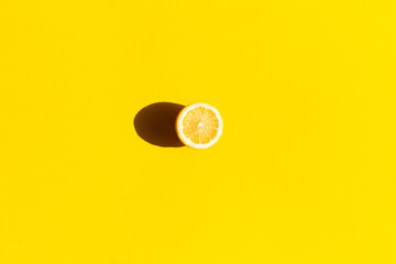 Fresh lemon cut in half, isolated on yellow background, flat lay.